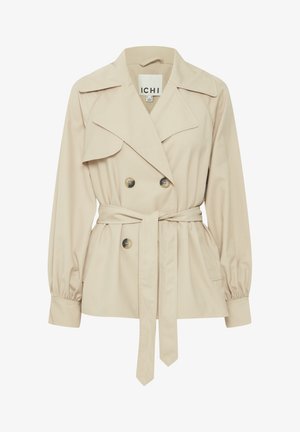 Impermeabile beige con bottoni doppi, ampie alette e cintura in vita. Presenta maniche a sbuffo e un tessuto liscio e texturizzato.