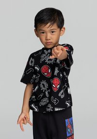 Czarna koszulka z grafikami w stylu kreskówkowym przedstawiającymi Spider-Mana i elementami komiksowymi, z krótkimi rękawami, luźny krój, w połączeniu z czarnymi spodniami.