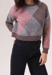 Pull en maille à design cropped, motif losanges dans des tons de rose, gris et marron. Encolure large avec bords-côtes aux poignets et à l'ourlet.