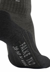 Chaussettes en laine de couleur gris foncé avec une texture côtelée, présentant un talon et une pointe renforcés. Taille et marque imprimées sur le côté en blanc.