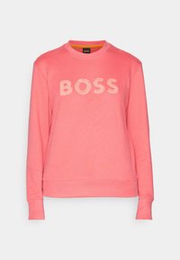 Sudadera rosa hecha de tela suave, con un cuello redondo y puños de canalé. En la parte delantera tiene el logo "BOSS" en un diseño texturado.