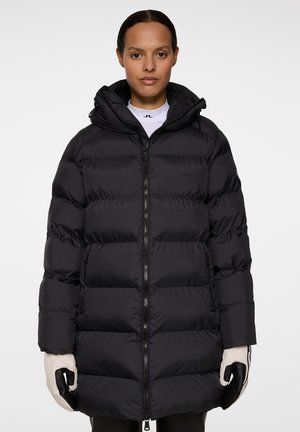 Schwarze Steppjacke mit Kapuze, die über ein gestepptes Design, einen Reißverschluss und elastische Bündchen verfügt. Das Material wirkt glatt und isoliert.