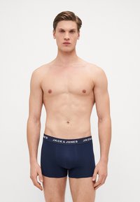 Mornariće bokserice izrađene od mekog materijala, s kontrastnom elastičnom trakom oko struka na kojoj se nalazi bijeli logo "JACK & JONES".