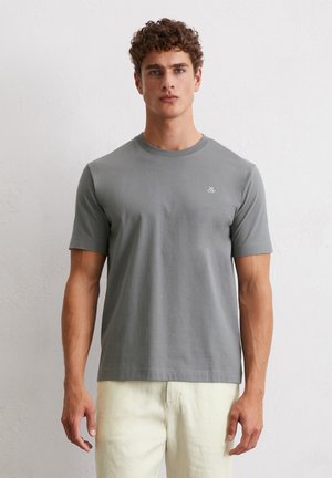 Gray cotton t-shirt with a crew neckline and short sleeves. Features a small white logo on the left chest. Smooth texture, relaxed fit.
