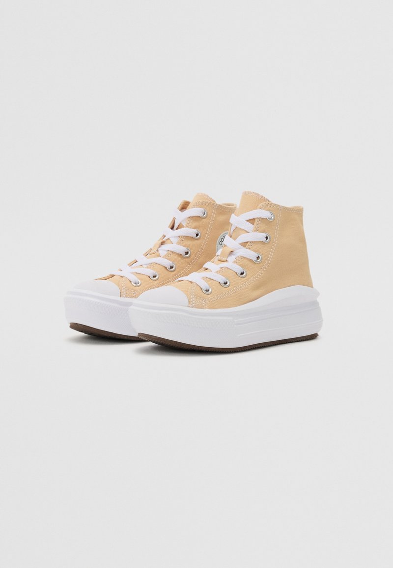 Zapatillas altas de lona color beige claro con cordones blancos y punta de goma, que cuentan con una gruesa suela de plataforma blanca y una suela exterior texturizada marrón.
