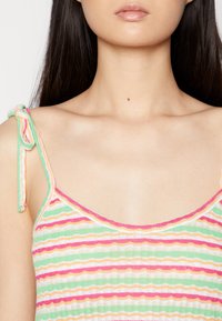 Top de tanque multicolorido com riscas horizontais em rosa, verde e amarelo, apresentando finas alças em tiras e uma textura canelada ao longo da gola.
