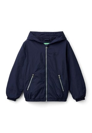 Granatowy, lekki kurtka z kapturem, z zapięciem na suwak z przodu oraz dwoma kieszeniami bocznymi na suwak. Posiada elastyczne mankiety oraz małe logo na piersi.