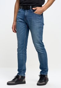 Blå denimjeans med slim fit, som har fem fickor, bälteöglor och subtila blekta detaljer på låren. Styla med svarta sneakers.