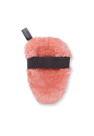 Soft, oval-shaped pink microfiber makeup remover pad with a wide black elastic strap and a small black fabric tag.