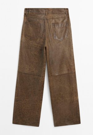 Bruine leren wijde broek met twee achterzakken en zichtbare stiksels, vanaf de achterkant weergegeven op een witte achtergrond.