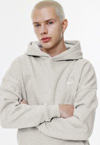 Felpa con cappuccio grigia chiara, dotata di polsini a coste, con logo sul lato sinistro del petto. Tessuto morbido e casual, vestibilità rilassata.
