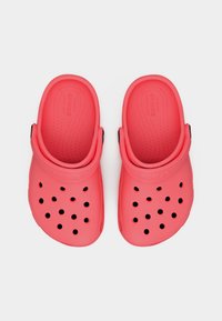 Paire de sabots Crocs rouges avec trous de ventilation et sangles de talon réglables sur un fond blanc, vus de dessus.