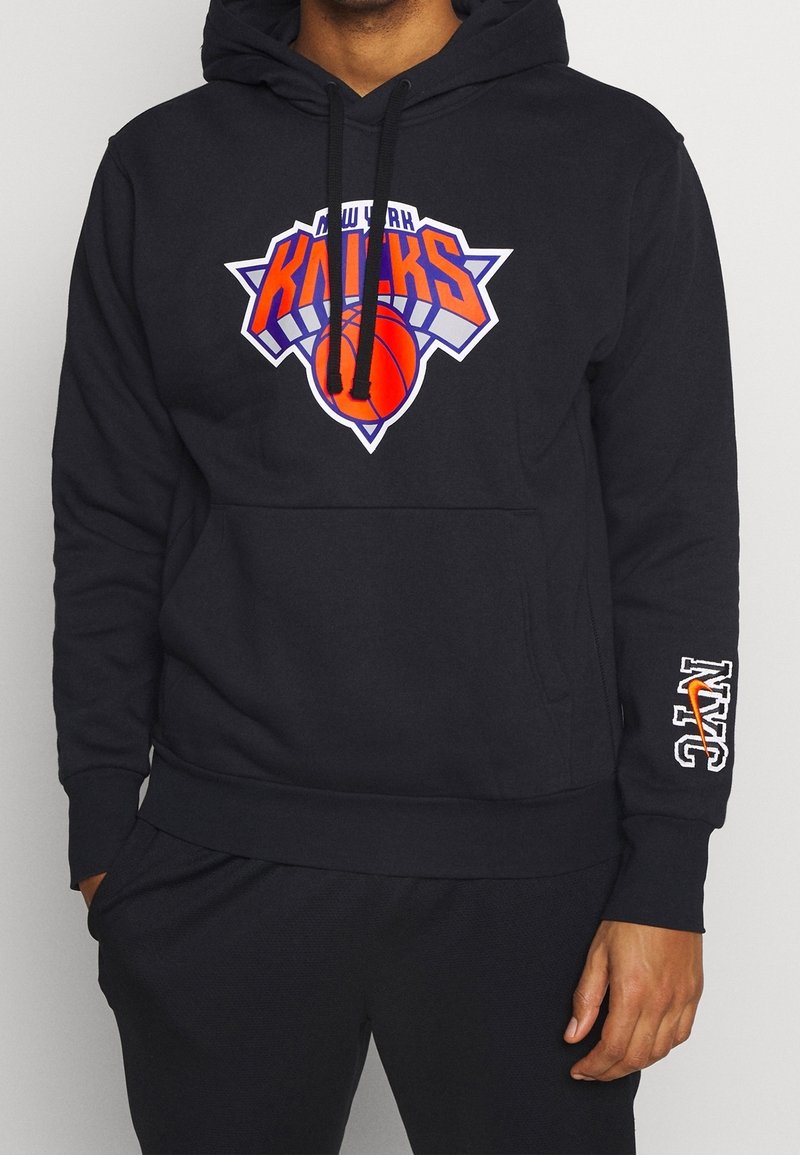 Sweat à capuche noir avec logo New York Knicks à l'avant, présentant des accents orange et bleu. Comprend une poche kangourou et le texte NYC sur la manche.