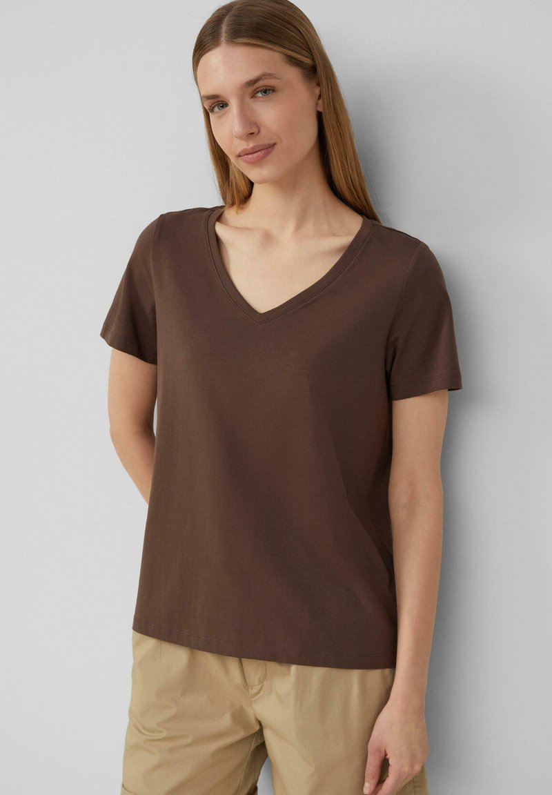 Bruine T-shirt met korte mouwen en een V-hals ontwerp. Gemaakt van zachte stof, heeft het een losse pasvorm en een gladde textuur.