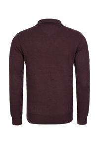 Jersey de color burdeos con mangas largas y cuello clásico. Presenta una textura suave y puños y dobladillo acanalados.