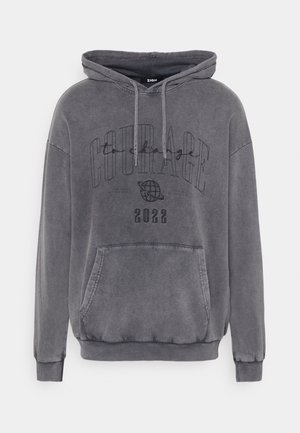 Felpa grigia con cappuccio, dotata di una tasca frontale, lacci e un design stampato che include la parola "CORAGGIO" e l'anno "2022."