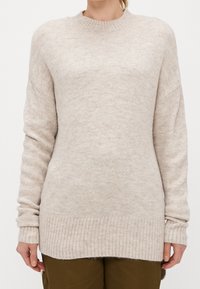 Beige pletený svetr s kulatým výstřihem, žebrovanými manžetami a lemem. Měkká textura a mírně oversized střih.