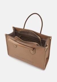 Brun läder tote-väska med topphandtag och präglad "VALENTINO"-logotype. Inuti finns enstaka dragkedjefack och brunt foder.