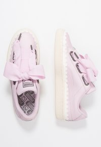 Rosa Turnschuhe mit glatter Textur, großem Schleifendetail, gewellten Kanten und grauen Akzenten. Sie verfügen über eine gemusterte Innensohle und eine Gummisohle.