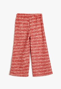 Pantaloni a gamba larga rossi e bianchi con una cintura elastica, caratterizzati da un motivo a quadri intrecciato su tutta la superficie.