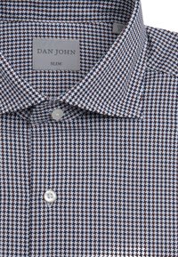 Slim-fit skjorte i et vævet mønster af marineblå, hvid og brun. Har en spids krave og en enkelt hvid knap ved kravens plis.