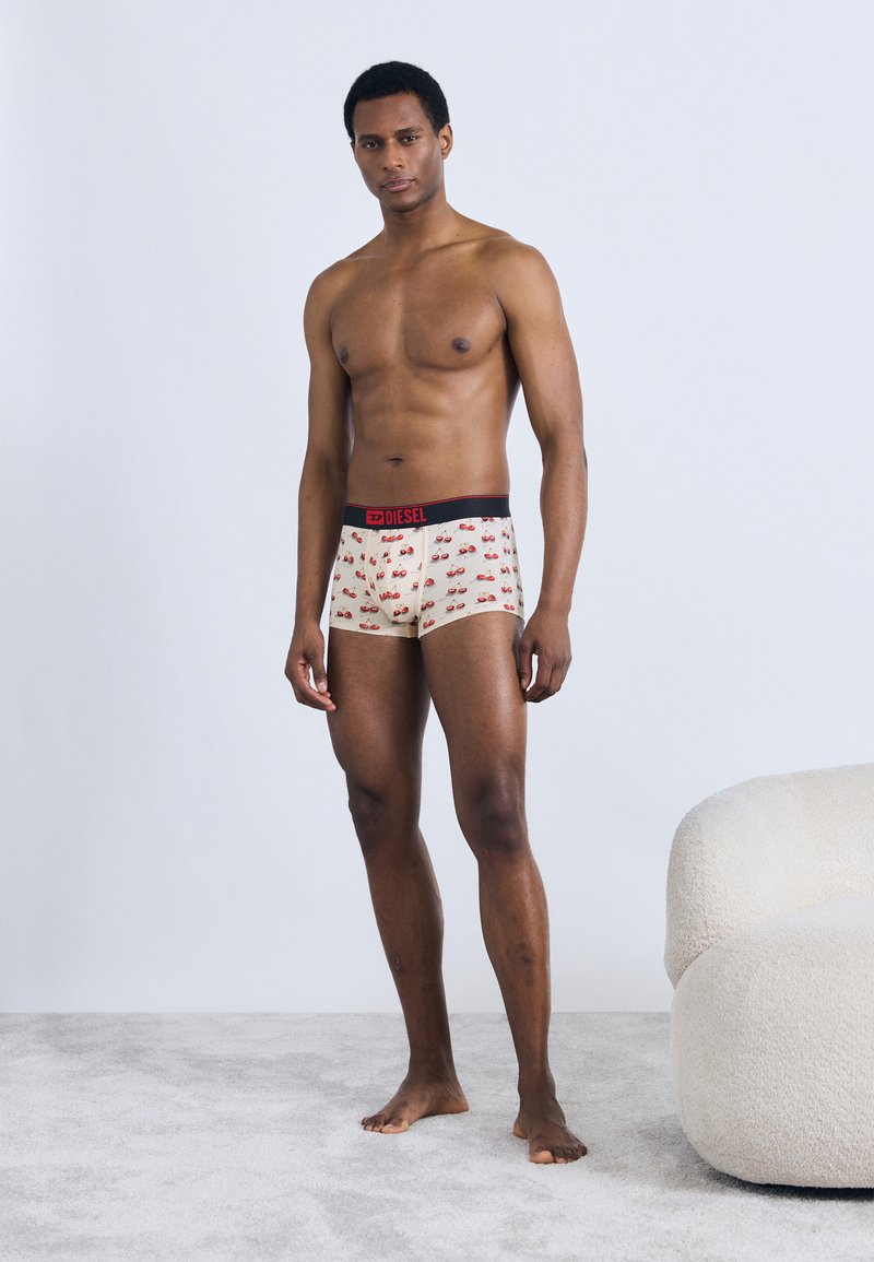 Ανδρικά εσώρουχα με κρεμ φόντο, κόκκινη μέση και σχέδιο με κεράσια. Απαλό, εφαρμοστό σχέδιο με μέτριο ύψος μέσης.