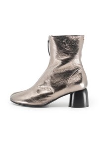 Stivale alla caviglia in metallo argento con chiusura a zip, punta affusolata e tacco spesso nero. Pelle texturizzata con una finitura liscia e lucida.