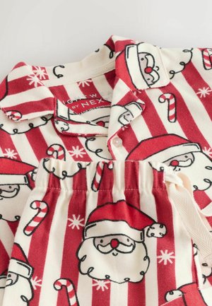 Set de pijamale roșii și crem, format dintr-o bluză cu nasturi și pantaloni cu talie elastică, decorat cu modele de Moș Crăciun și bastoane de zahăr.