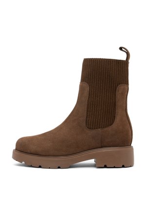 Stivale alla caviglia in pelle scamosciata marrone con pannelli laterali in elastico a coste. Suola in gomma marrone spessa. Presenta un occhiello sul retro per una facile calzata.