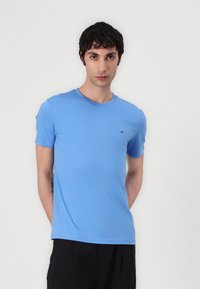 Helle blaue Baumwoll-T-Shirt mit Rundhalsausschnitt und kurzen Ärmeln. Verfügt über ein kleines Logo-Detail auf der Brust und einen lockeren Schnitt.