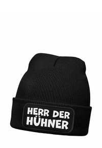 Black knit beanie with a folded cuff featuring a rectangular patch that displays the text "HERR DER HÜHNERN" in bold white letters.