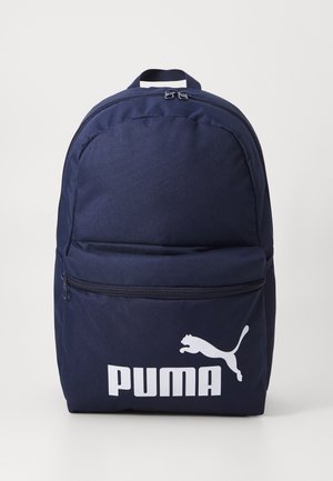 Zaino blu navy con tessuto strutturato, tasca frontale con cerniera e logo Puma bianco sul davanti. Dotato di manico superiore per il trasporto.