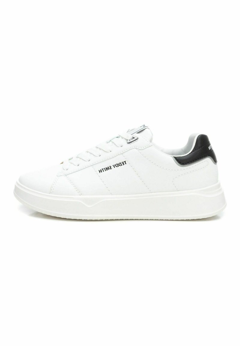 Zapatillas blancas de cuero con un acento en el talón negro, presentan un diseño de cordones, cuello acolchado y suela de goma texturizada. Nombre de la marca en el lado.