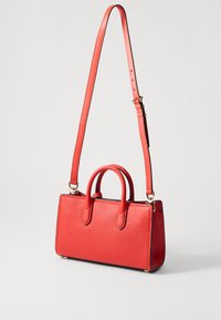 Borsa a tracolla rossa in pelle con finitura testurizzata, dotata di doppi manici e una tracolla removibile, accentuata da dettagli in oro.