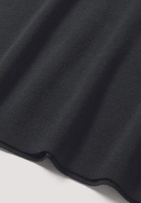 Schwarzer Strickstoff mit einer glatten Textur, der sich weich anfühlt und einen subtilen Stretch aufweist, mit sanften, sanft geschwungenen Falten.