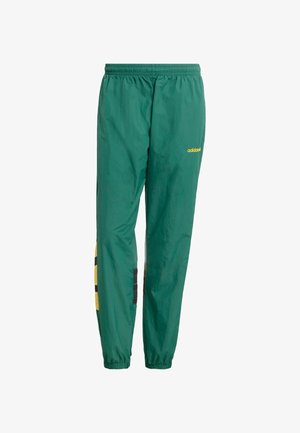 Zielone spodnie przeciwdeszczowe wykonane z lekkiego materiału, wyposażone w elastyczny pas, żółte logo oraz czarno-żółte wzorzyste akcenty.