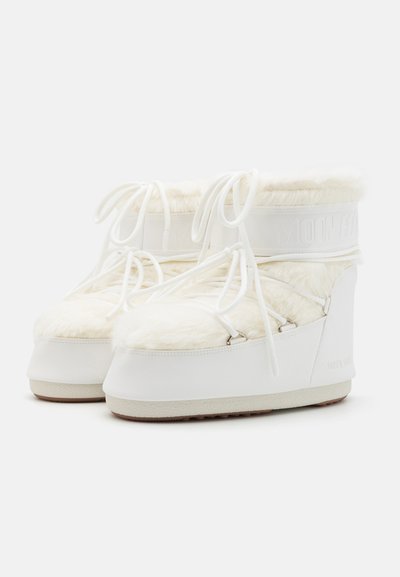 Hvite høye støvler med pelsaktig overdel, flat snøring og tykk gummisåle. "MOON BOOT" merkeinnprenting på hvit stropp og side.
