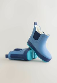 Stivali in gomma blu impermeabili con fodera bianca morbida, dettagli blu scuro, suole testurizzate e linguette per una facile calzata e rimozione.