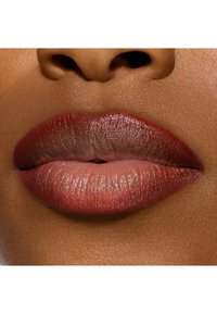Matte läppfärg med en gradient som övergår från djup burgund till mjuk nude. Läpparna är fylliga med naturlig textur, mot en varm hudtonsbakgrund.