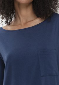 Middendonkblauwe katoenen shirt met een brede halslijn en korte mouwen, voorzien van een borstzak met gestikte randafwerking.