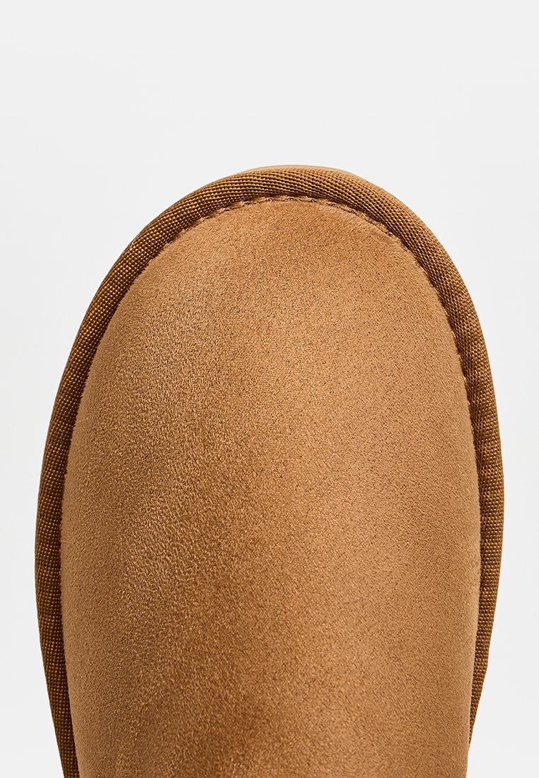 Bruine suède laars met een ronde neus, gestructureerde bovenkant en een gladde zijafwerking. Voering van een zacht materiaal voor extra comfort.