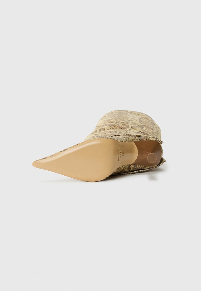 Spitz zulaufender Knöchelboot mit Schlangenlederoptik und glatter, tan (hellbrauner) Sohle, von unten auf einem weißen Hintergrund fotografiert.