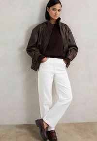 Pruun nahast pommija ehk bomber-jakk, tume kudumi sviiter, valged sirged teksad ja burgundi värvi loafersid paksu musta tallaga. Siledad tekstuurid ja kontrastsed värvid.