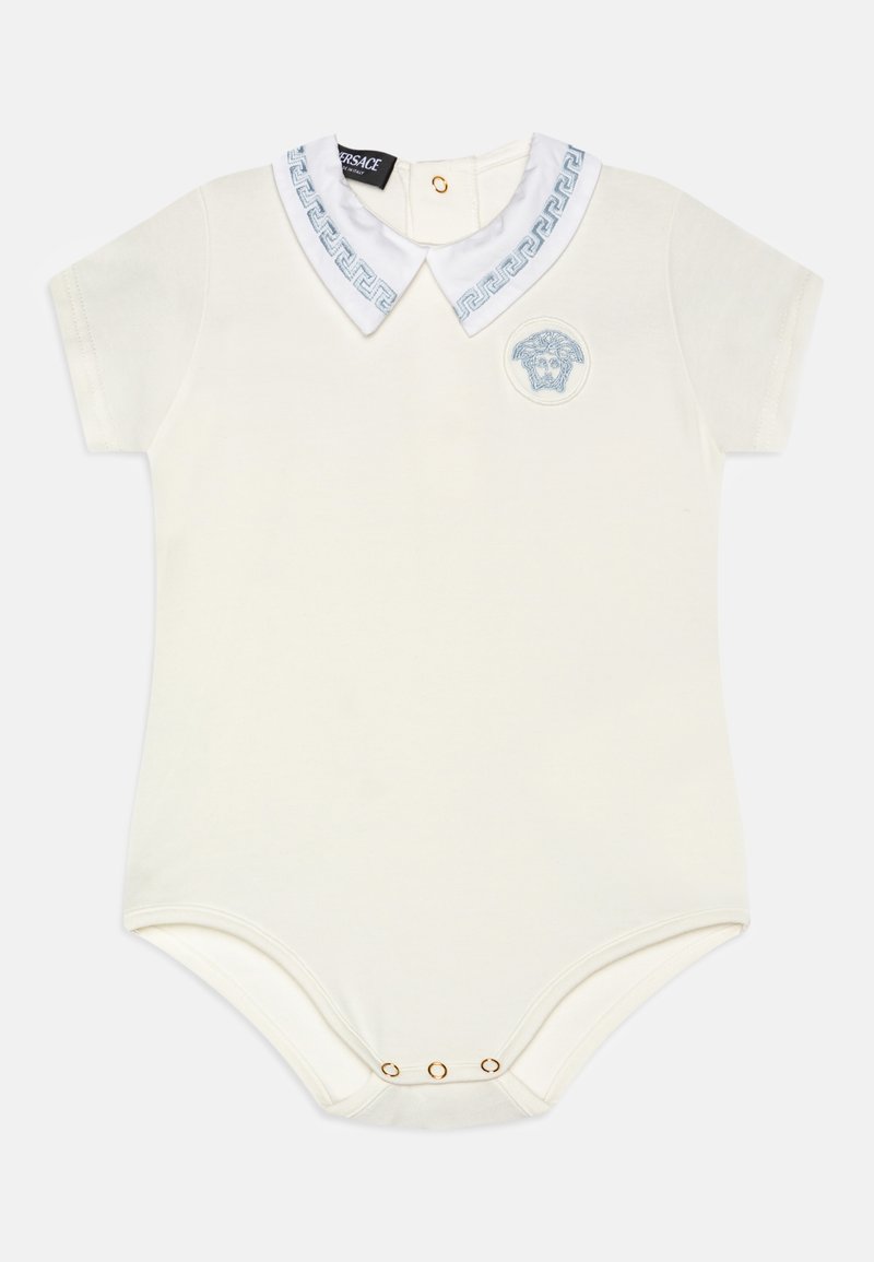 Κρεμ κορμάκι κοντό μανίκι με λευκό γιακά και μπλε ελληνικό σχέδιο, εμβληματική στάμπα μπροστά και χρυσά κουμπώματα στο κάτω μέρος.