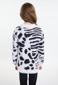 Maglione fuzzy bianco con design a stampa animale nera, con scollatura rotonda, maniche lunghe e una texture morbida. Vestibilità casual, lunghezza media.