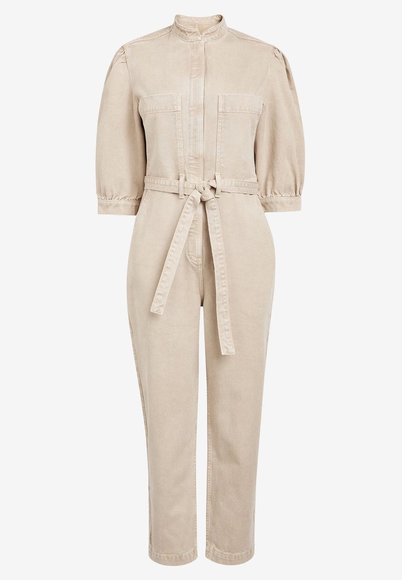 Combinaison beige à manches longues avec col montant, ceinture à nouer à la taille, deux poches sur la poitrine et pantalons fuselés.