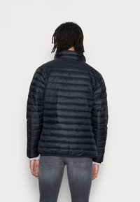 Puffer jacket in solid black, featuring horizontal quilted pattern, high collar, and ribbed cuffs. Lightweight with smooth texture.