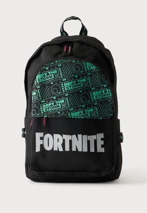 Čierny Fortnite batoh s predným sieťovaným vreckom, zeleným vzorom kompasu na hornej časti a dizajnom textu "DEFY THE STORM".