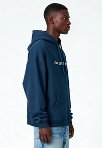 Felpa con cappuccio blu navy in cotone, dotata di tasca a marsupio frontale e cordini. Testo "I Told You That" stampato sul petto.