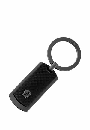 Sort tekstureret rektangulær nøglebrik med en rund metalnøglering, der er fastgjort, med en lille præget logo på brikens overflade.